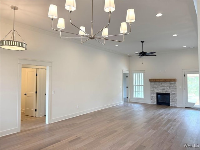 unfurnished living room featuring ceiling fan with notable chandelier, baseboards, a high ceiling, and ornamental molding