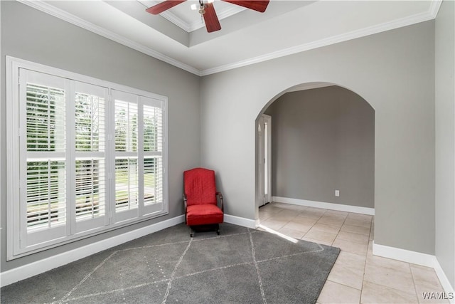 unfurnished room with arched walkways, baseboards, a ceiling fan, tile patterned flooring, and crown molding