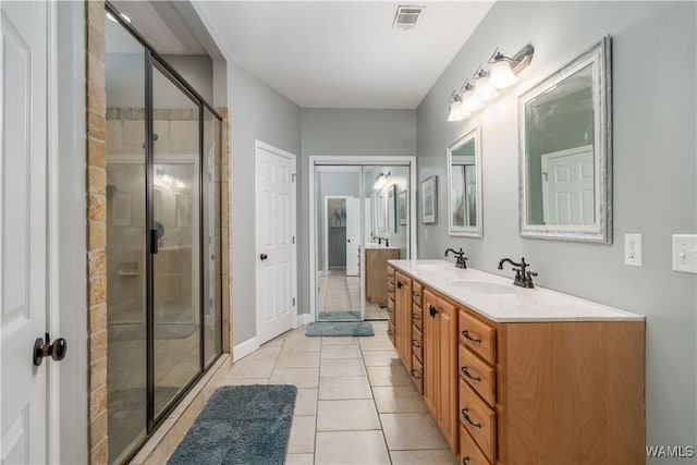 full bathroom featuring a shower stall, a sink, double vanity, tile patterned flooring, and visible vents