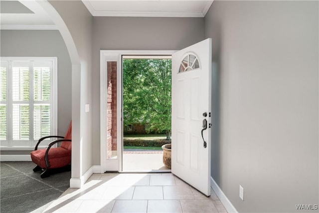foyer entrance featuring arched walkways, a wealth of natural light, and baseboards