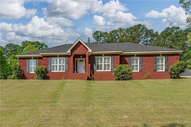 ranch-style home with brick siding, a front yard, and roof with shingles