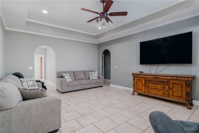 living area featuring crown molding, a ceiling fan, light tile patterned flooring, arched walkways, and a tray ceiling