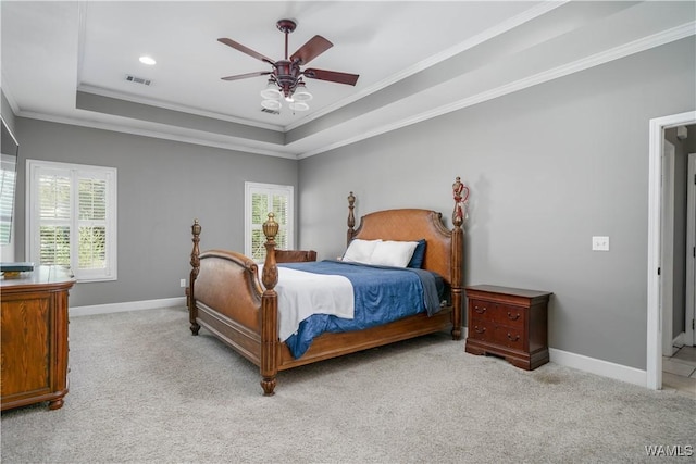 bedroom featuring light carpet, crown molding, a tray ceiling, and visible vents