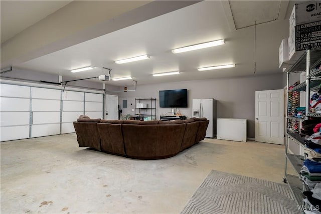 garage featuring white fridge with ice dispenser, refrigerator, and a garage door opener