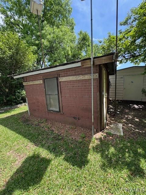 1511 Service St, Demopolis, AL 36732 - view of side of property with a lawn, brick siding, and an outbuilding