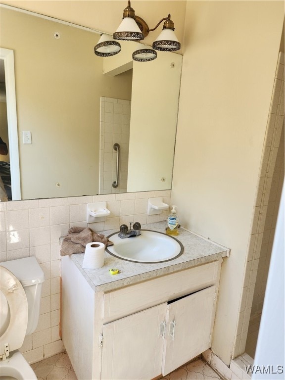 bathroom featuring tile patterned flooring, vanity, toilet, and tile walls