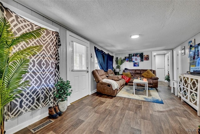 living area featuring a textured ceiling, wood finished floors, and visible vents