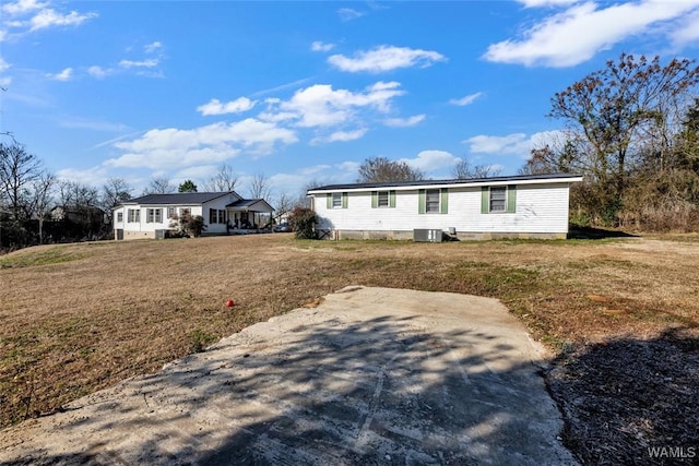 manufactured / mobile home featuring a front lawn and central AC unit