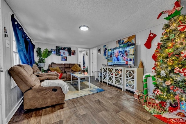 living area with a textured ceiling and wood finished floors