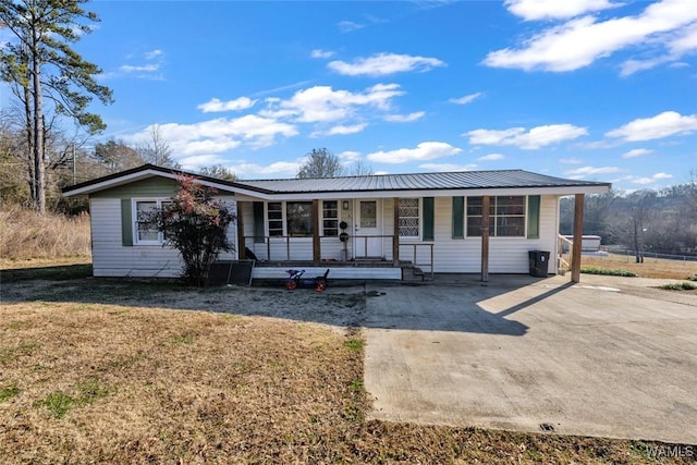 ranch-style home with a front yard, covered porch, and metal roof