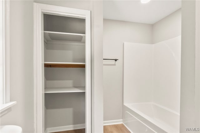 bathroom featuring wood-type flooring and tub / shower combination