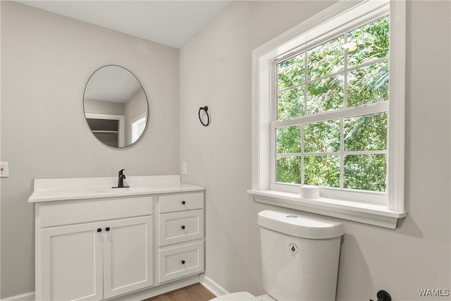 bathroom featuring a wealth of natural light, vanity, and toilet