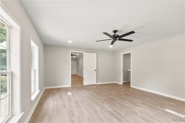 empty room with ceiling fan and light hardwood / wood-style flooring