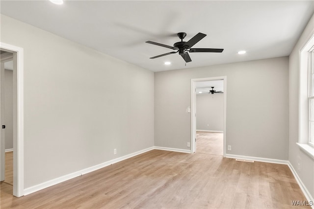 empty room with light hardwood / wood-style floors, ceiling fan, and a healthy amount of sunlight