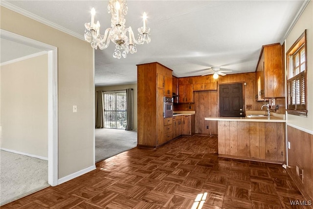 kitchen featuring brown cabinets, a peninsula, light countertops, and stainless steel oven