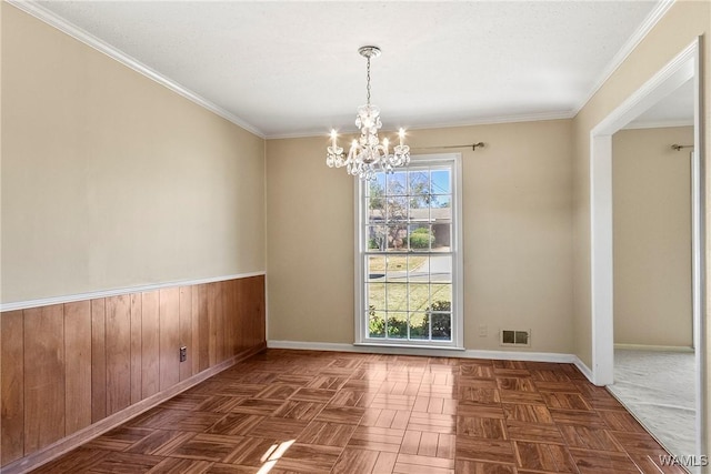 empty room with visible vents, baseboards, an inviting chandelier, and crown molding