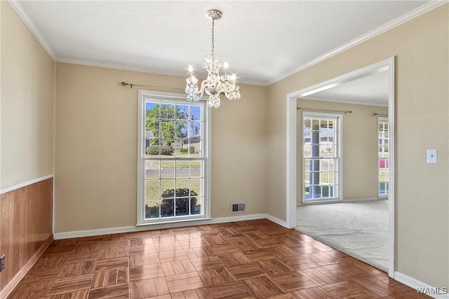 unfurnished room featuring baseboards, visible vents, and ornamental molding