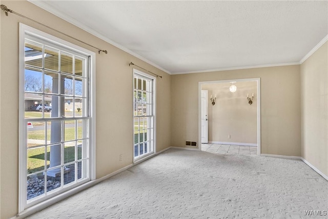 unfurnished room featuring baseboards, visible vents, carpet floors, and ornamental molding