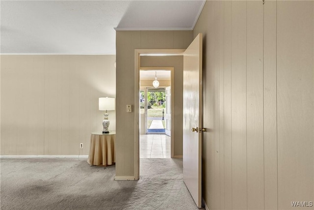 corridor featuring baseboards, carpet, and crown molding