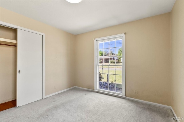 unfurnished bedroom featuring a closet, baseboards, and carpet flooring