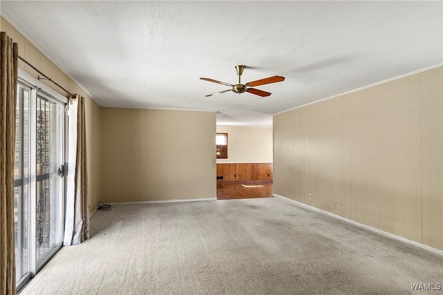 carpeted spare room with plenty of natural light, a textured ceiling, and ornamental molding