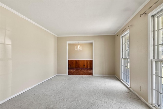 unfurnished room featuring baseboards, carpet, an inviting chandelier, and ornamental molding