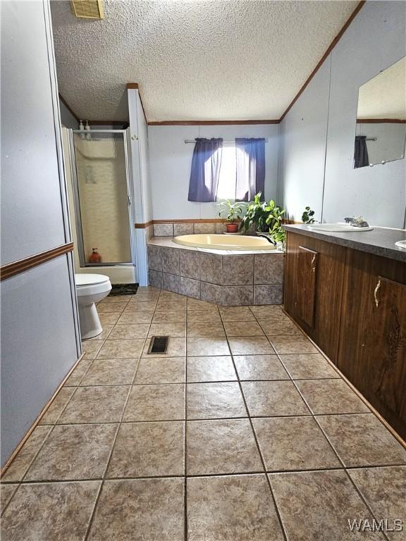 full bathroom with tile patterned floors, a textured ceiling, toilet, vanity, and shower with separate bathtub