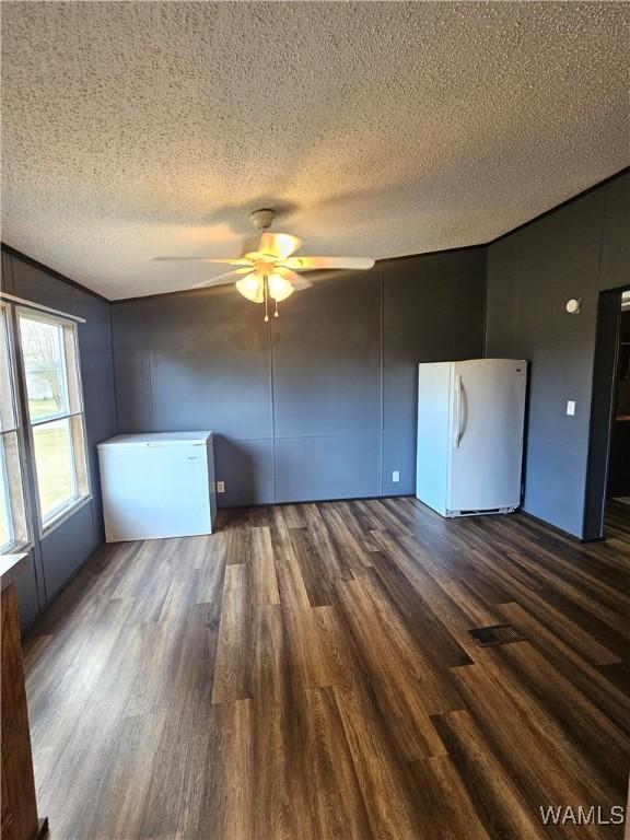 spare room with ceiling fan, dark hardwood / wood-style flooring, and a textured ceiling