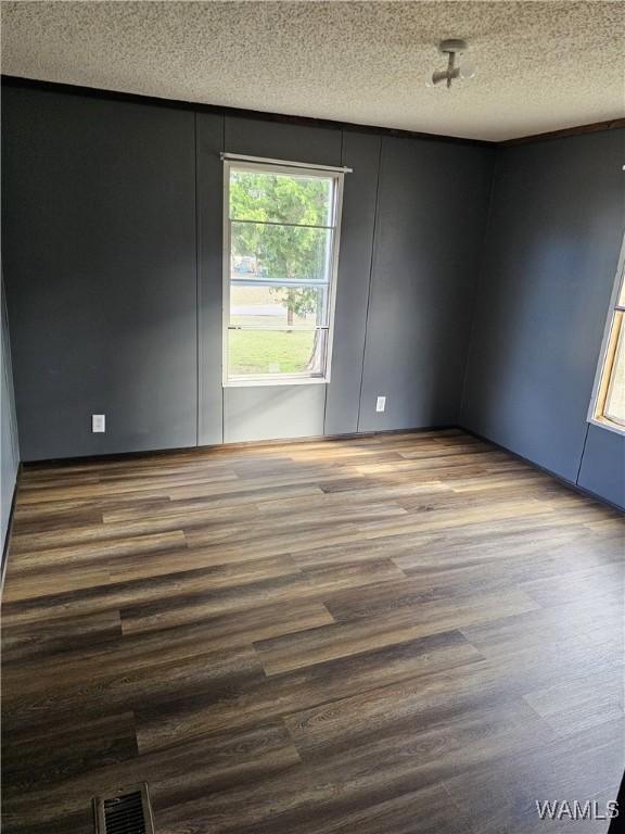 spare room featuring hardwood / wood-style floors and a textured ceiling