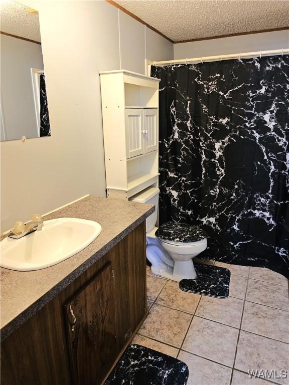 bathroom featuring tile patterned floors, vanity, toilet, and a textured ceiling