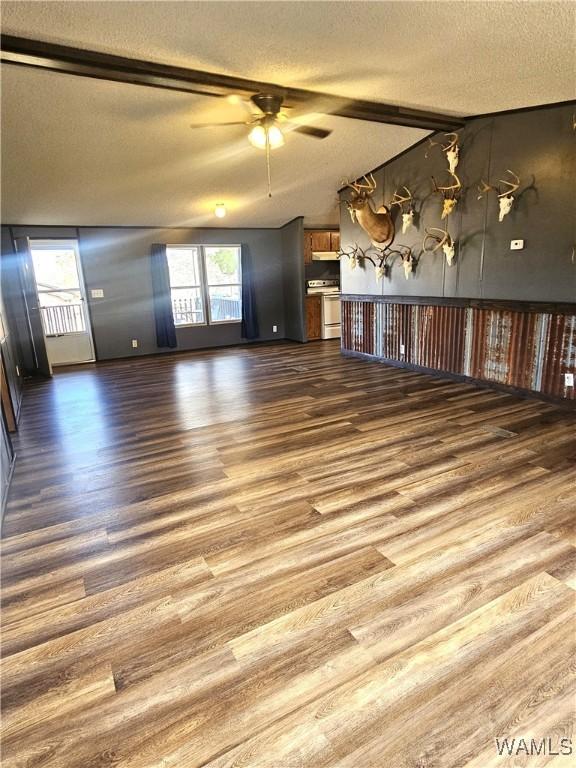 unfurnished living room with ceiling fan, dark hardwood / wood-style flooring, and a textured ceiling