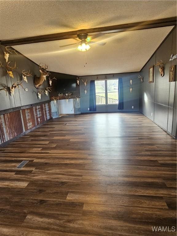 unfurnished room with ceiling fan, dark hardwood / wood-style flooring, and a textured ceiling