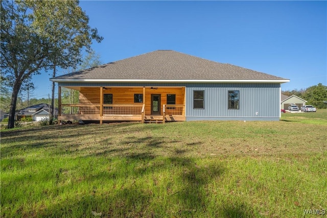 back of property with covered porch and a lawn