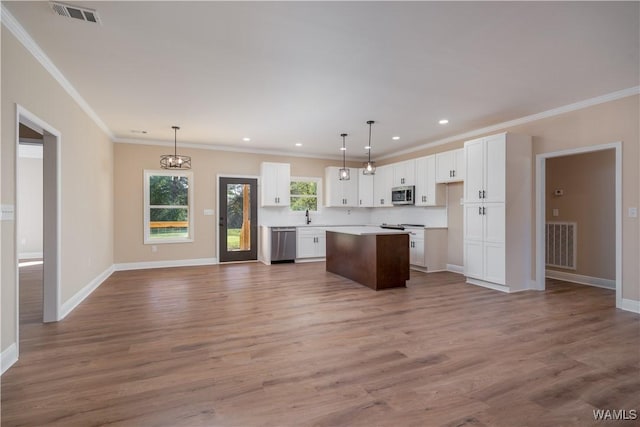 kitchen featuring pendant lighting, white cabinetry, appliances with stainless steel finishes, and a kitchen island