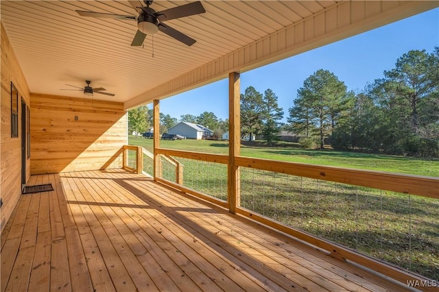 wooden deck featuring ceiling fan and a lawn