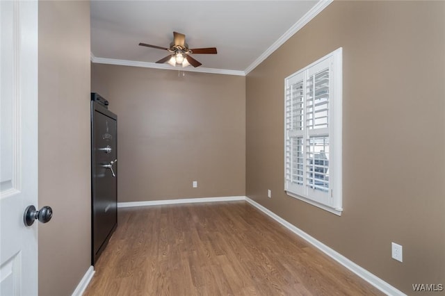 spare room with wood-type flooring, ceiling fan, and ornamental molding