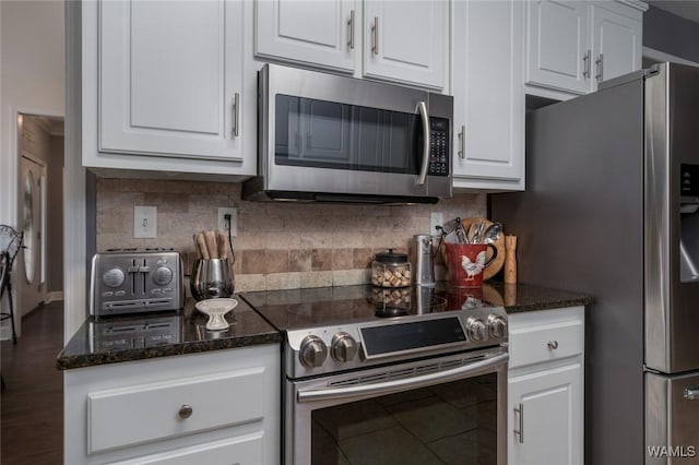 kitchen with backsplash, white cabinetry, dark stone counters, and appliances with stainless steel finishes