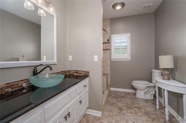 bathroom featuring vanity, toilet, and a shower