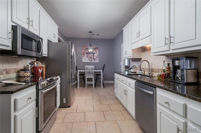 kitchen with white cabinets, decorative light fixtures, stainless steel appliances, and sink