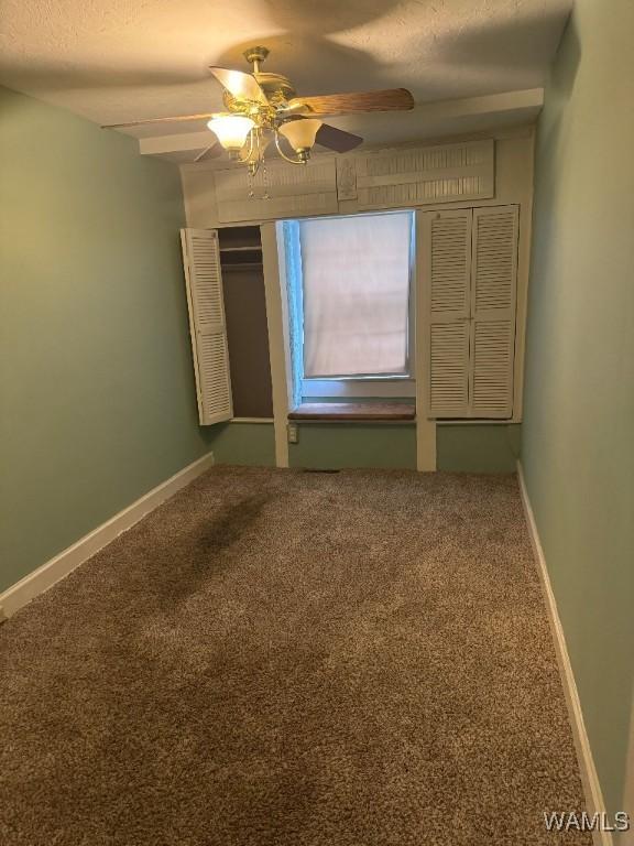 unfurnished bedroom featuring a textured ceiling, ceiling fan, and carpet