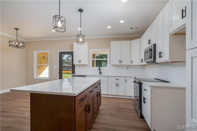 kitchen featuring ornamental molding, tasteful backsplash, light stone countertops, and appliances with stainless steel finishes