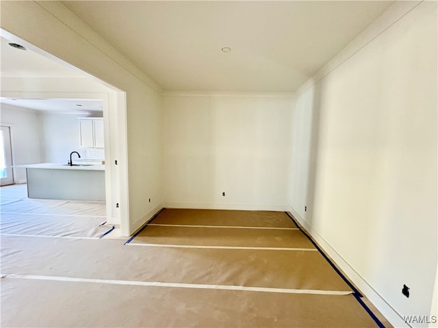 spare room with ornamental molding and sink