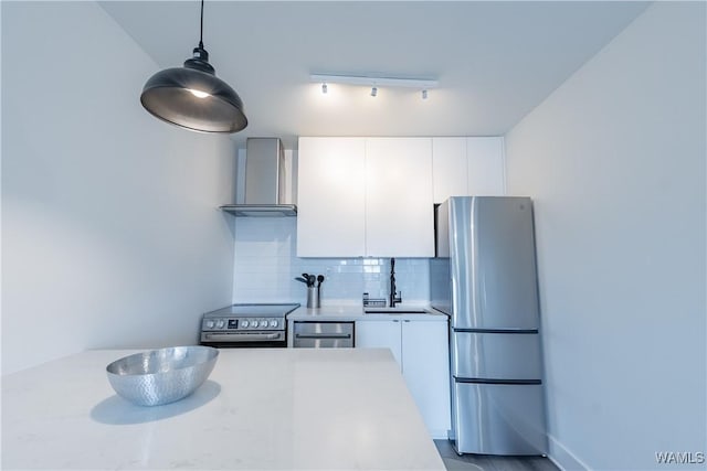 500 Grace St Unit 304, Tuscaloosa, AL 35401 - kitchen featuring stainless steel appliances, wall chimney exhaust hood, tasteful backsplash, light countertops, and white cabinetry