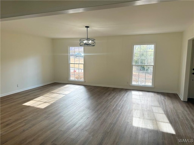 unfurnished dining area featuring dark hardwood / wood-style flooring and an inviting chandelier