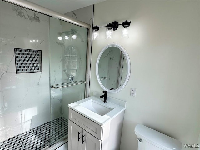 bathroom featuring vanity, toilet, and a shower with door