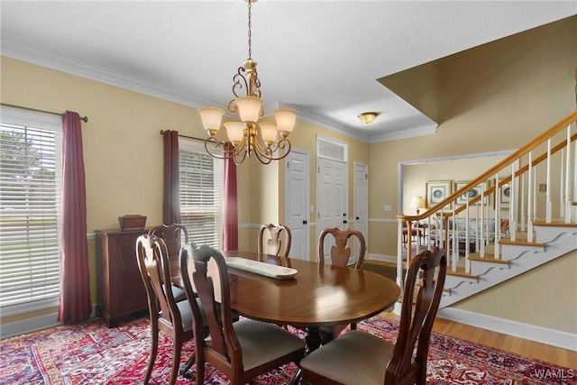 dining area with an inviting chandelier, crown molding, and hardwood / wood-style floors