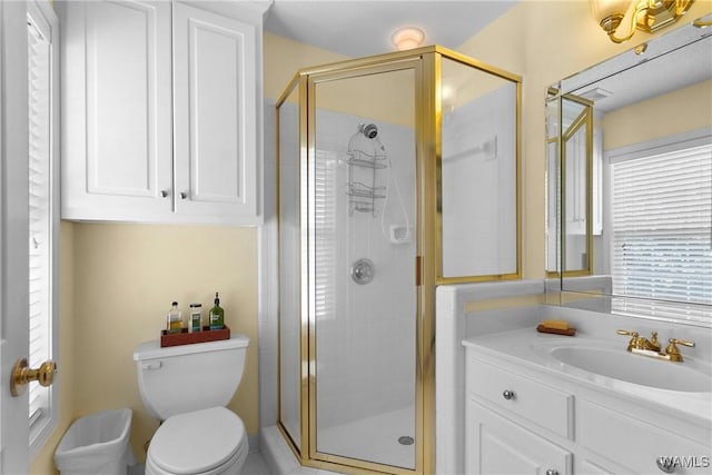 bathroom with toilet, a shower with door, and vanity