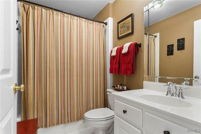 bathroom featuring toilet, a shower with shower curtain, and vanity