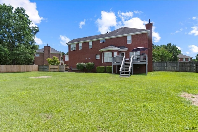 back of house featuring a deck and a yard