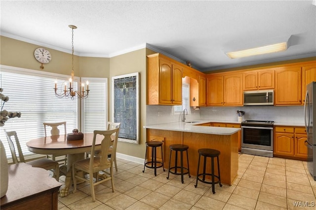 kitchen featuring appliances with stainless steel finishes, kitchen peninsula, light tile patterned floors, ornamental molding, and backsplash